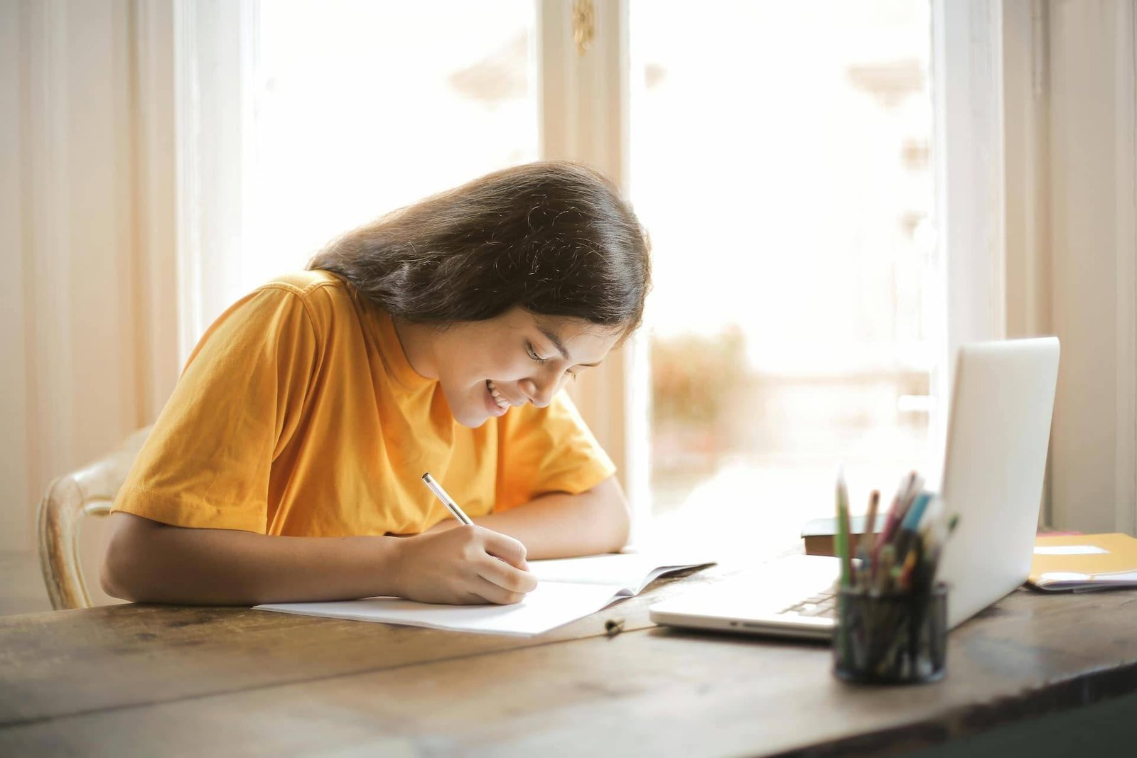 adolescente tomando notas de sus clases de inglés virtual