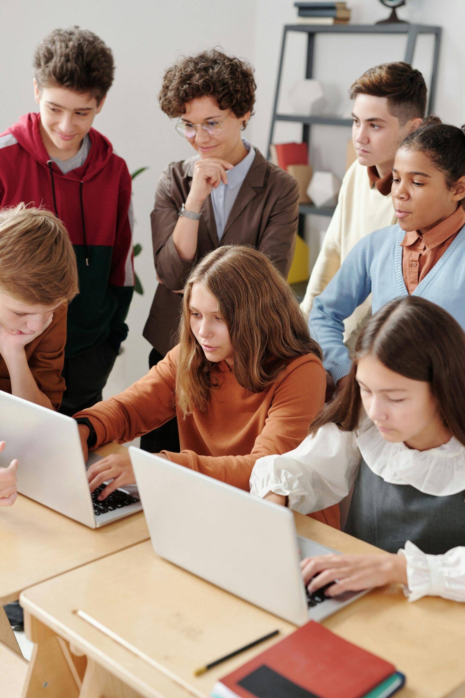 Grupo de ninos viendo como una nina toma sus clases de inglés virtual